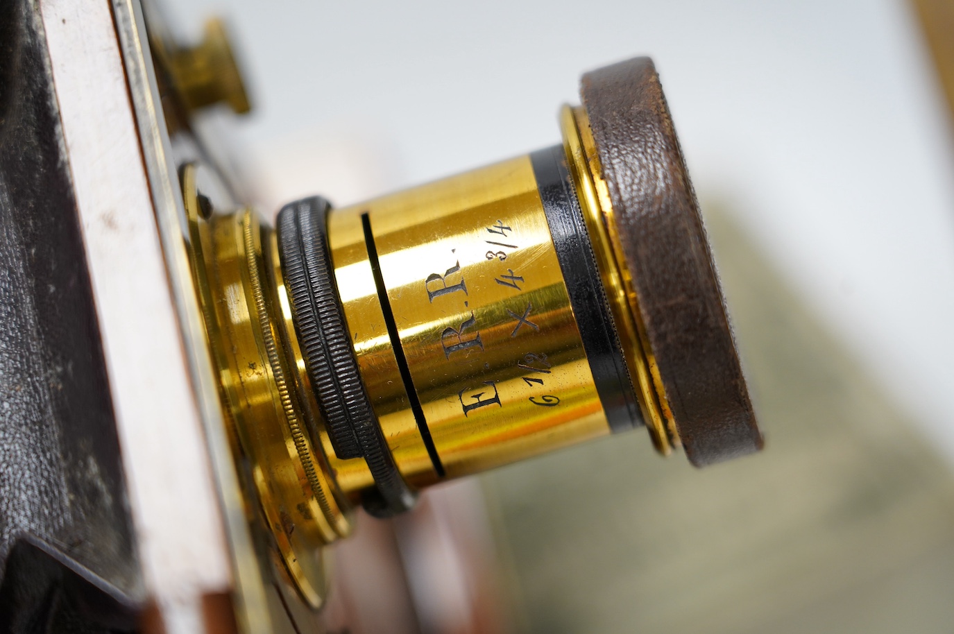 A late 19th century brass and mahogany half plate bellows camera with oak tripod stand and a lens engraved ‘ERR 6.5 x 4.75’, together with a good quantity of contemporary accessories including a shutter action, ten negat